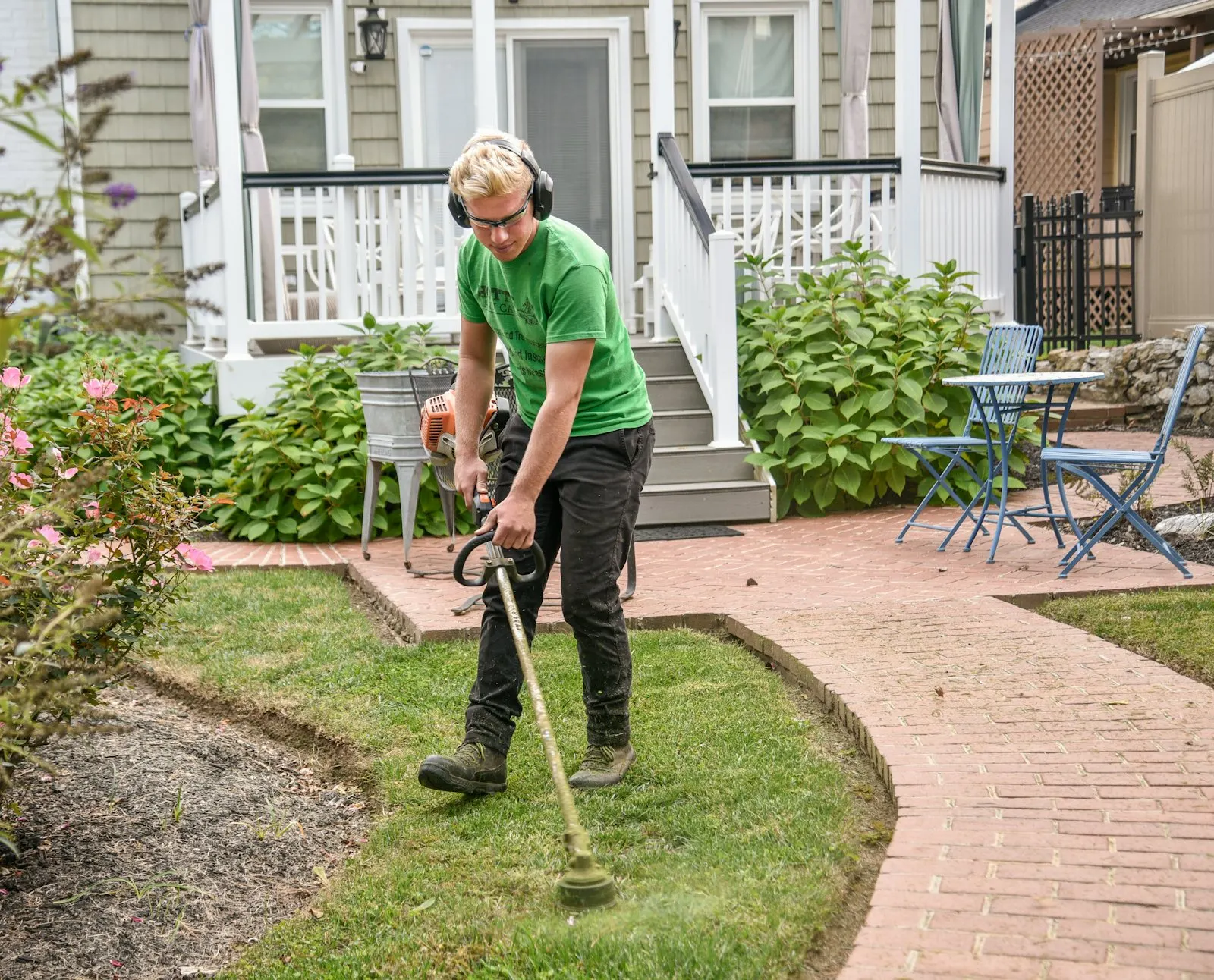 String trimmer cutting a sharp edge along a Garland sidewalk.